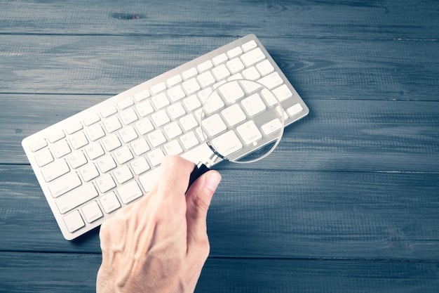 A hand hovering over a keyboard with a magnifying glass focused on the screen, symbolizing careful examination of online job offers. The background is blurred to keep focus on the action.