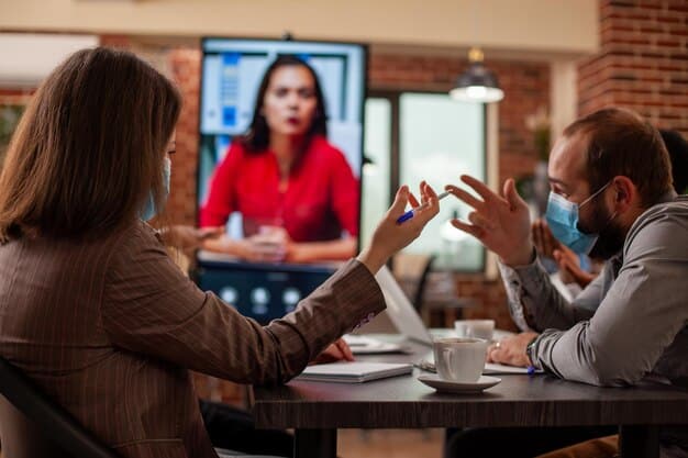 A team using sign language during a virtual meeting, highlighting the importance of inclusive communication practices and accommodation for employees with hearing impairments in a remote work setup.