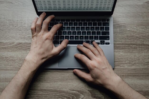 A close-up of a person's hands typing on a laptop with a focused expression, set in a modern home office. This represents the dedication required for freelance writing. Books and a cup of coffee are visible in the background.