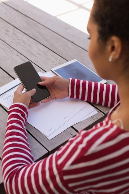 A close-up shot of a person using a mobile app to file an insurance claim. The app interface is clean and intuitive, showing options for uploading photos, providing details, and tracking the claim status. The background is blurred to keep the focus on the app and the user's interaction.